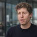 Sam Altman mid-interview, 3/4 front, navy sweater — the named CEO who ruled out a 2026 IPO.