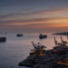 Red Sea commercial port at dusk with cargo ships and gantry cranes, illustrating shipping risk near Mocha and approaches to Bab el-Mandeb.