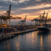 Container port with gantry cranes and cargo ships at dusk, conveying China export and trade-surplus activity without branded labels.