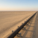 A long desert crude pipeline on steel supports, the East-West corridor after the attack that shut the line.