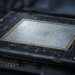Close-up of an advanced semiconductor die on a dark substrate, conveying mass production of AI accelerator silicon.