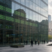 New York financial plaza with green ticker glow in glass, as Wall Street futures stay green but pare after a hot-core CPI print.