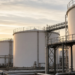 Crude storage tanks at late-day light as WTI and Brent lock Friday settles.