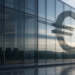 Modern glass eurozone finance building with large euro symbol and empty briefing podium, framing the ECB rate decision without readable deposit-rate figures.