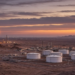 Desert oil storage tanks and a gas flare at twilight, illustrating Saudi Arabia's official August OPEC crude output print.