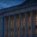 Neoclassical institutional facade with columns at twilight, suggesting U.S. monetary-policy and Fed decision atmosphere without documents.