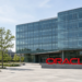 Red Oracle monument wordmark on a glass HQ plaza — the letters read ORACLE.