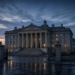 Neoclassical government finance building at dusk with wet plaza reflections, illustrating Treasury-market reaction as yields stayed elevated.
