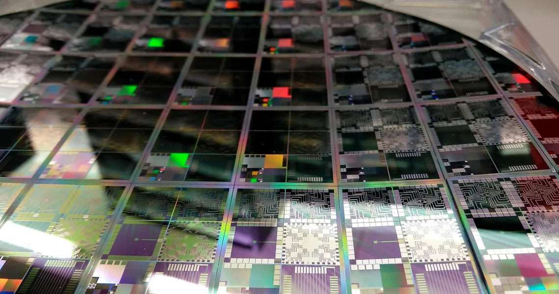 Semiconductor wafer in microelectronics manufacturing light, suggesting chip M&A and edge-AI silicon.