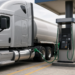 Photoreal modern fleet tractor-trailer fueling at a clean diesel island with the nozzle in the chassis saddle tank, illustrating U.S. diesel topping $6 a gallon.