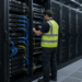 A technician inspects server racks in a data-center aisle, illustrating AI hardware demand.