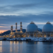 Northern European LNG or gas terminal on a snowy coastline at twilight, conveying Europe's gas-storage and supply-security pressure.