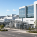 A semiconductor fabrication campus with a process-utility yard and white fab buildings, no vendor marks.