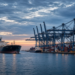 Container port at dusk with cargo ships and gantry cranes, suggesting Iran-China oil-for-credits trade channel reporting without military hardware or dollar totals on image.