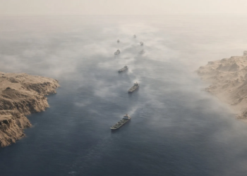 Aerial view of tankers in a hazy narrow strait between arid coasts, conveying Hormuz transit-flow uncertainty and residual crude risk premium.