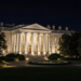 The White House North Portico illuminated at night after a U.S. decision on military help.