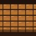 Stacked copper cathode-style plates in warm industrial light, suggesting copper market tightness without price labels.