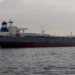 Crude oil tanker in a strait under open sky, illustrating Hormuz shipping and cargo-insurance cost pressure.