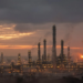 Oil refinery distillation towers and flares at dusk, illustrating U.S. diesel and refining-capacity pressure.